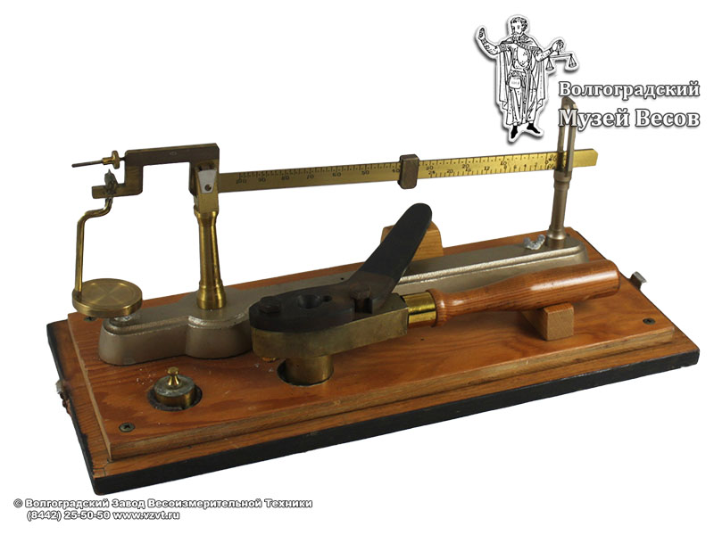 Scales on a wooden base with a movable weight. The manufacturer is unknown, the early XX century.