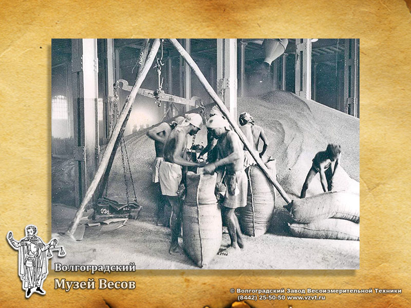 Weighing of sacks on an equal-arm balance. Old photograph.
