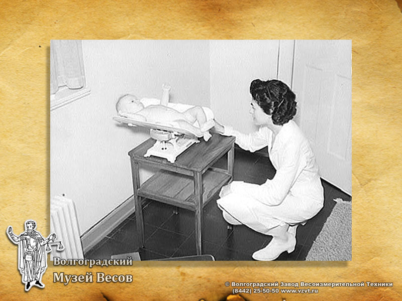 Weighing a baby on scales for babies. Retro photo.
