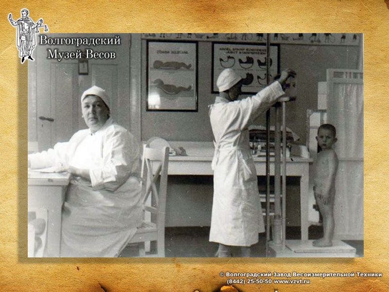 Weighing of a child on a medical scales. Old photograph.